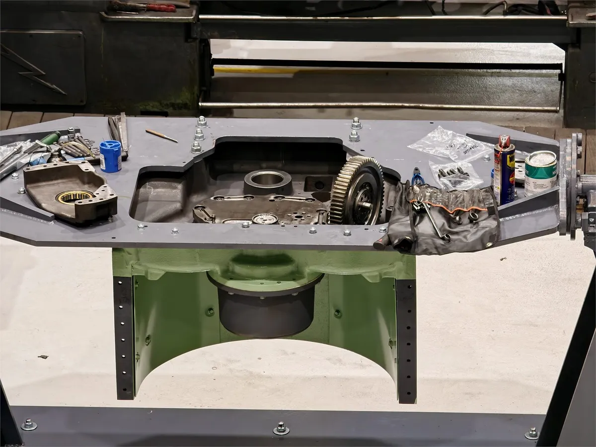 EMD turbocharger housing split open on the bench with the gear train and parts laid out