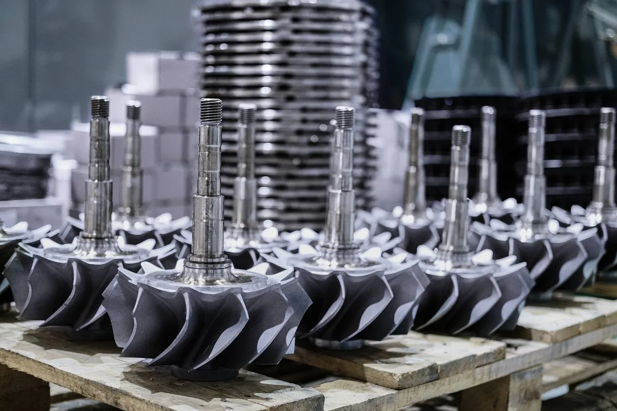 Pallet of turbocharger shafts, with diffusers and nozzle rings in the background