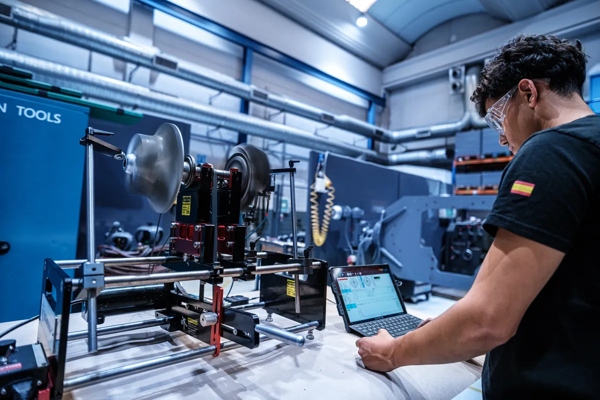 Technician running the balancing software beside a rotor mounted on the portable machine