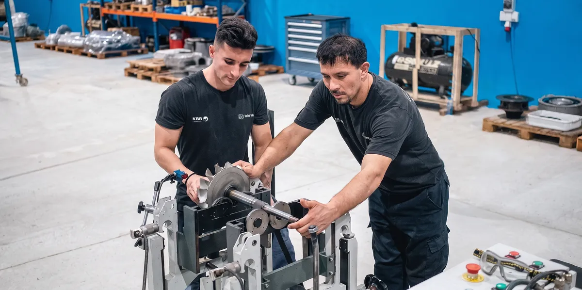 Two Turbo Internacional technicians balancing a turbocharger rotor at the Asuncion workshop