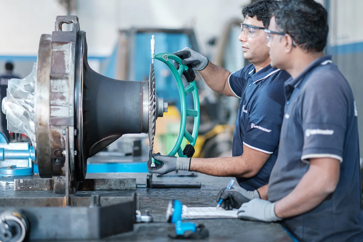 Technicians inspecting a turbine wheel at the Karachi workshop