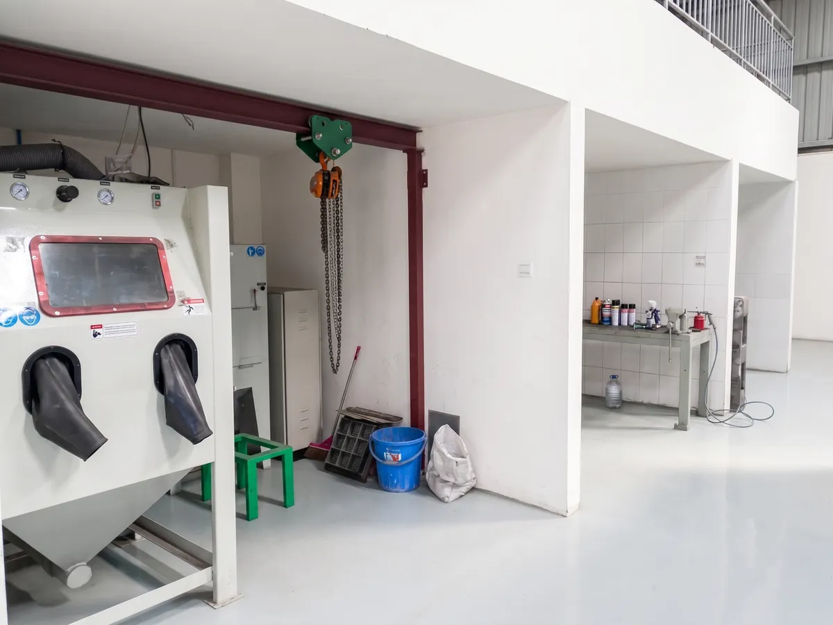 Cleaning area at the Dhaka workshop, with the blasting cabinet and the wash bays