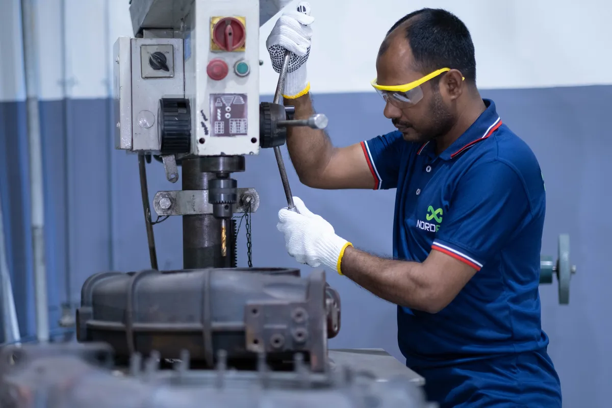 Technician working a turbocharger casing on the bench press at Dhaka