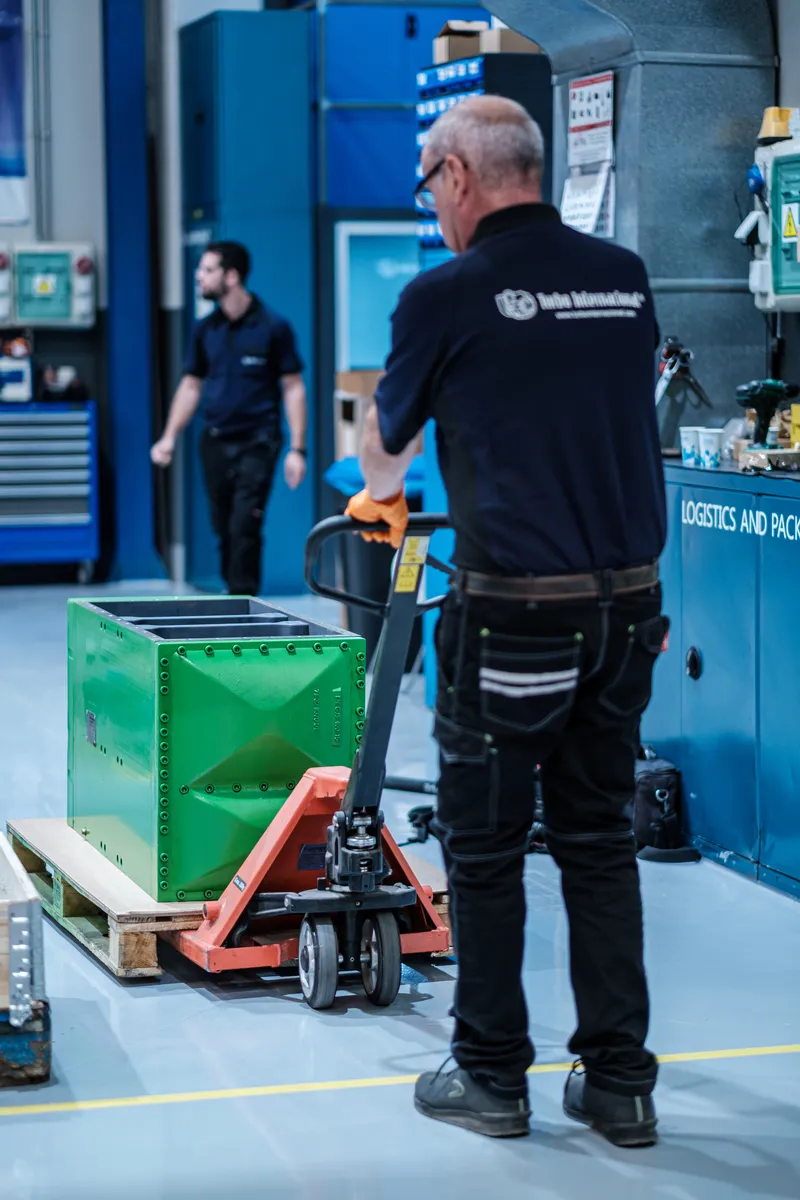 Technician moving an overhauled charge air cooler to the packing area