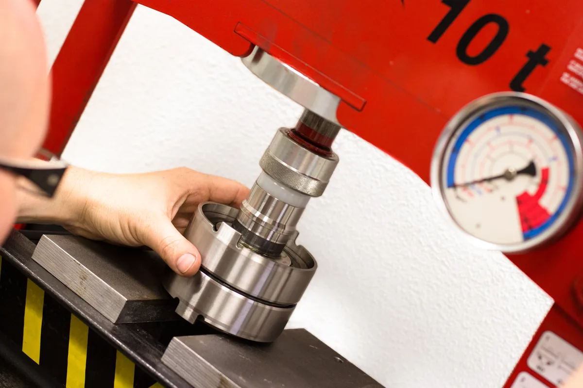 Bearing being press-fitted onto the pack under a hydraulic press